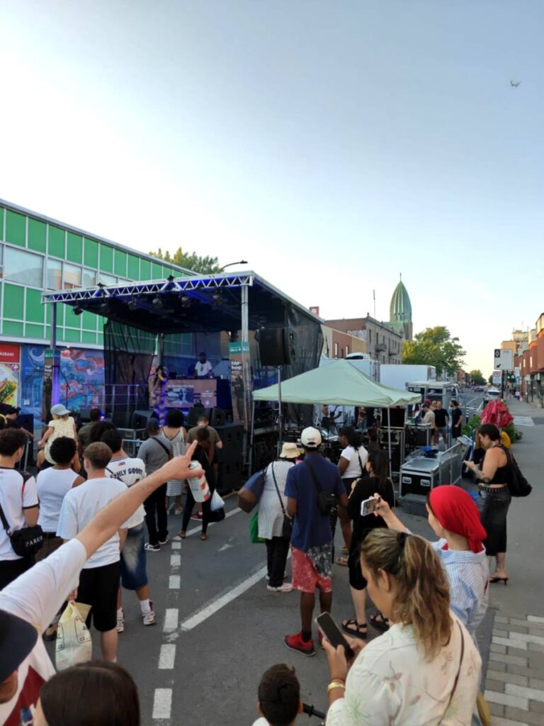 Scène Stageline SL100 sur la Plaza St-Hubert alimentée par le Power Pack 100K d'Eco Location, foule devant la scène